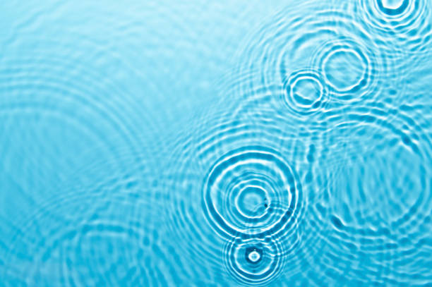 istock Defocus blurred blue color water ripple surface clear calm texture background with splashing bubbles water drop. Abstract and nature concept. Shiny water wave sunlight reflection shining copy space. 1727102081