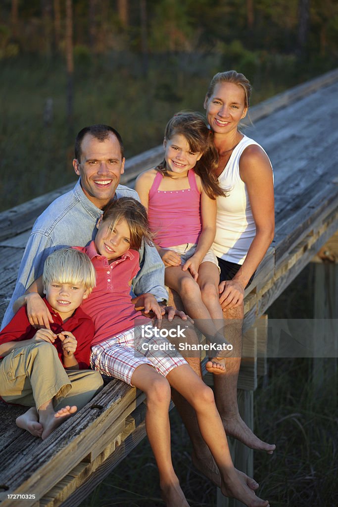 Familia de cinco sentado en el muelle - Foto de stock de 30-39 años libre de derechos