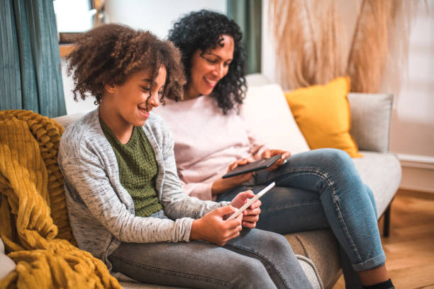 istock Mother-Daughter Time on the Sofa with E-Readers 1727118302
