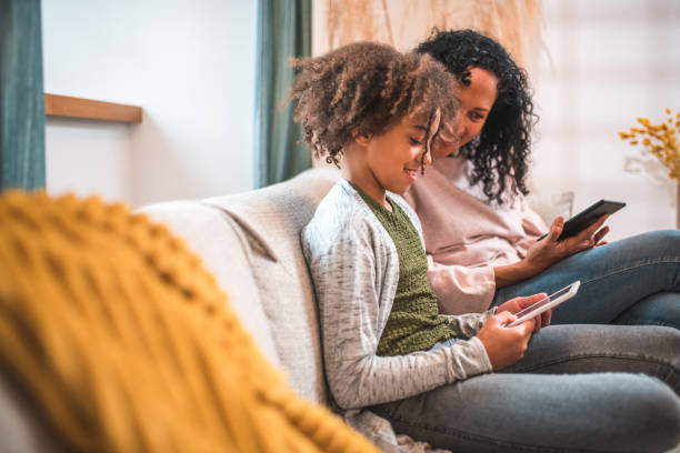 istock Quality Time with E-Readers: Hispanic Mother and Mixed Race Daughte 1727118304