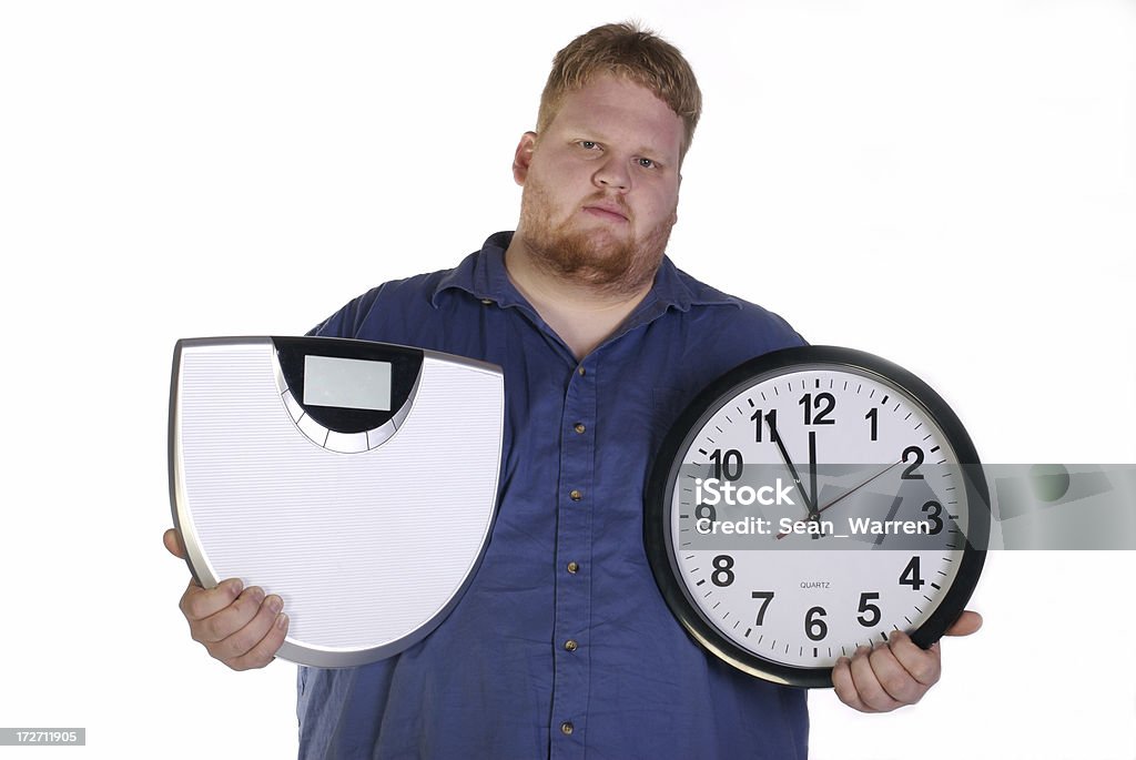 Weight Loss - Big Man This man holds both a scale and a clock representing his need to change his lifestyle. Adult Stock Photo