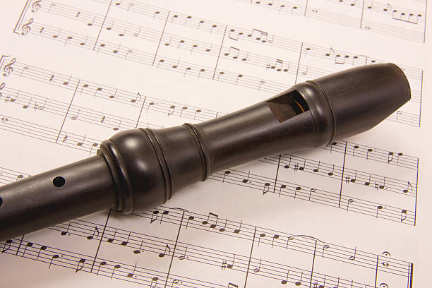 Recorder and Music A wooden recorder resting on a sheet of music. sheet music recorder stock pictures, royalty-free photos & images