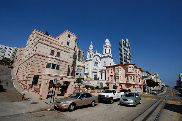 Street in San Francisco, CA at corner where a senior center and church are located among victorian apartments as seen thru wide angle lens