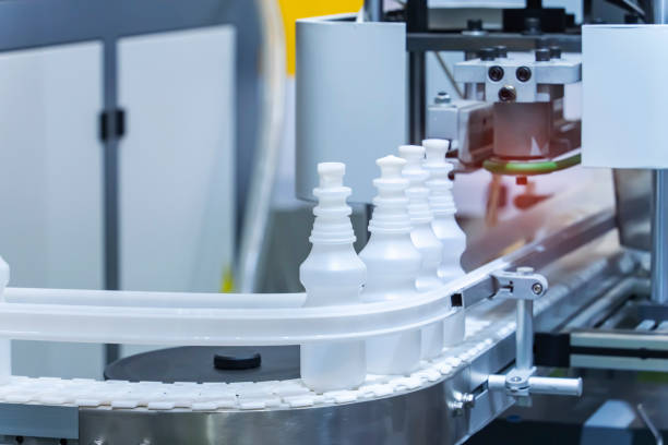istock Moving polypropylene white bottles on conveyor belt of automatic liquid filling machine 1727130807
