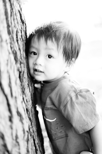 Child putting his ear to a tree