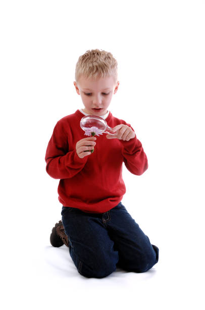 istock kneeling boy looking at flower 172713383