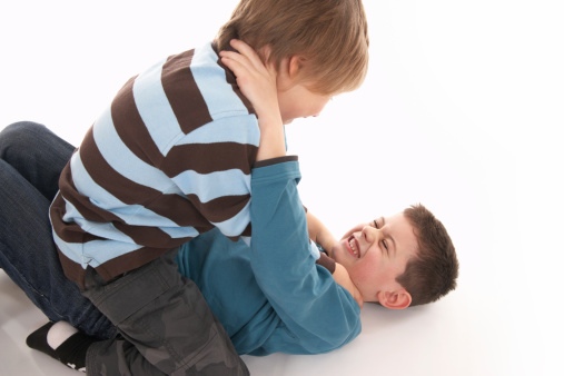 two boys quarreling and retching each other on white floorrelated images: