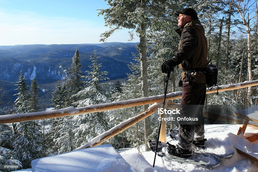 Starszy człowiek w Snowshoes na punkt widokowy - Zbiór zdjęć royalty-free (Chata w górach)