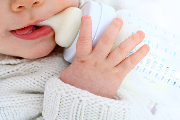 ベビーミルクを飲む - feeding bottle ストックフォトと画像