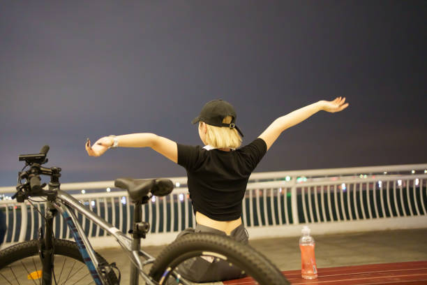 Back view of girl riding a bicycle at night