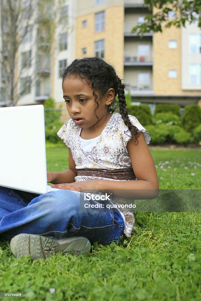 Afro-americana primária de idade Menina com Laptop na grama ao ar livre - Royalty-free Aprender Foto de stock