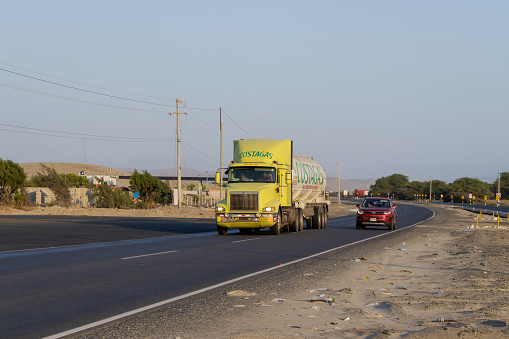 View of a truck trailer and a car on the highway in the afternoon, in Casma, Ancash - Peru. July 29, 2023