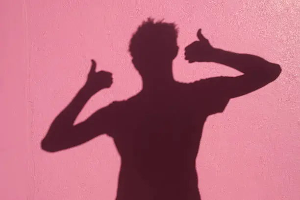 Shadowman gives two thumbs way up on a bright pink wall