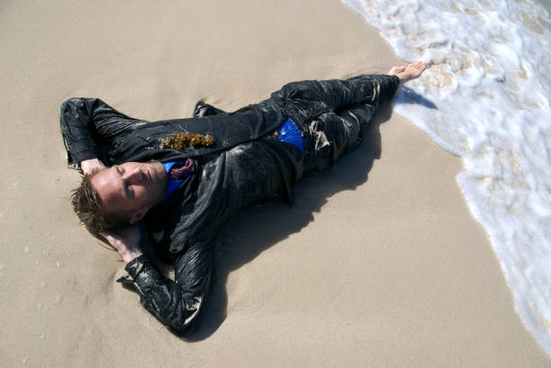 naufrago uomo d'affari si trova sulla riva - stranded beached beach businessman foto e immagini stock