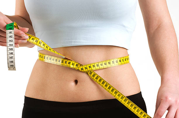 Woman measuring her waist stock photo