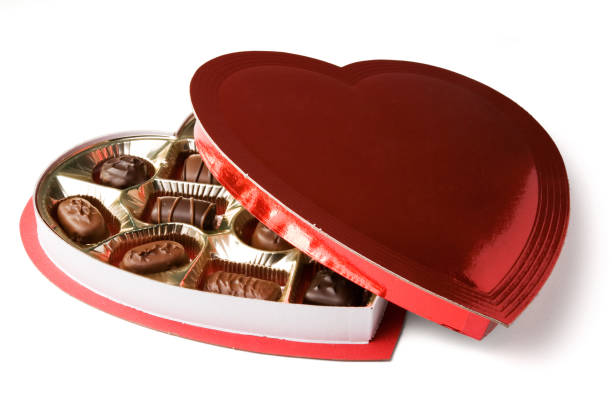 A half-open heart-shaped box of chocolates for Valentine's Day.  Isolated on white with clipping path.
