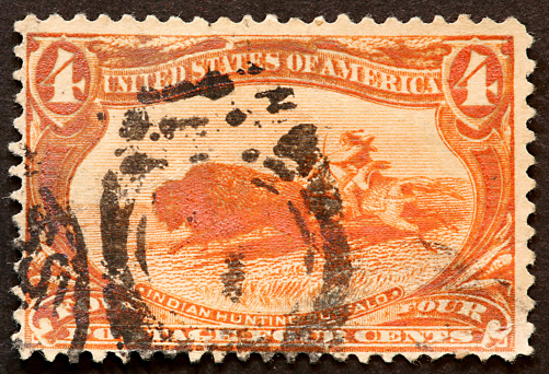 1898 postage stamp of an American Indian hunting buffalo on horseback.