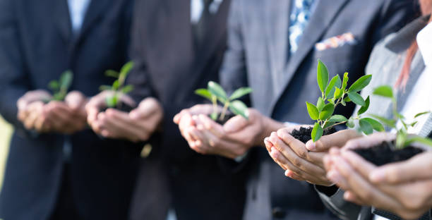 istock Business people holding plant or sprout together in unity as CSR commitment.Gyre 1727185956