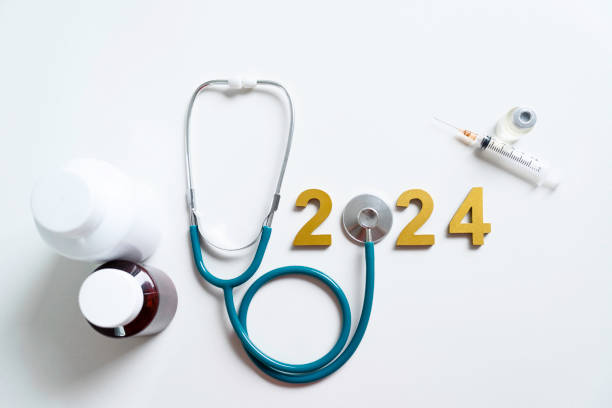 金色の木製の数字2024と聴診器、ヘルスケアの新年あけましておめでとうございます.心臓の健康、健康保険のコンセプト、新年の決議の目標.薬の治療と毎年の健康診断。