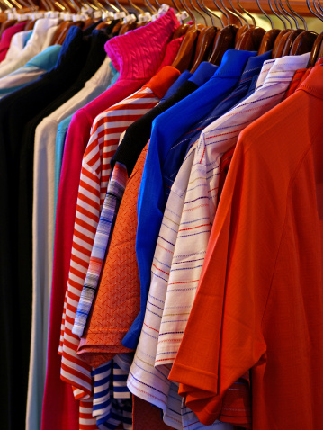 A brightly colored display of new men's shirts in a clothing store.