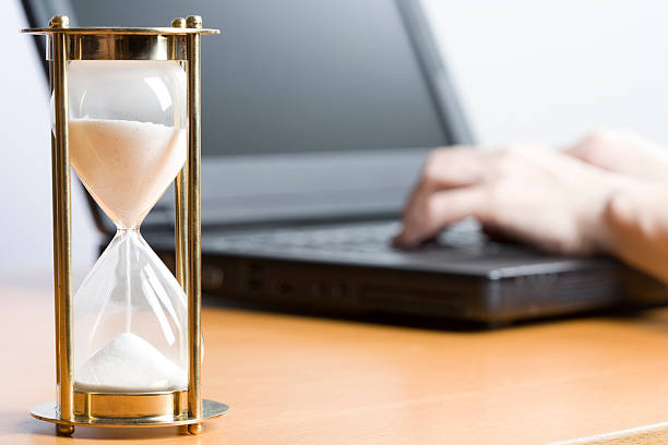 istock Close up of a large egg timer and a person working on laptop 172721500