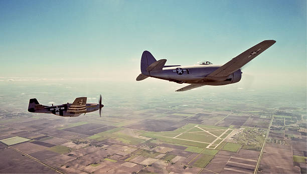 Famous World War II Fighters P-51 and P-47 Over Airport "A P-47 Thunderbolt (closest), also called the Jug, flies in formation with a P-51 Mustang over an airfield in south Texas.  Both aircraft have been restored to flying condition and appear as they would have during World War II." p51 mustang stock pictures, royalty-free photos & images