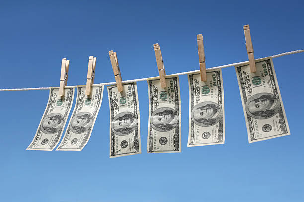 Hanging $100 bills Hanging $100 bills on a clothesline. money laundering stock pictures, royalty-free photos & images
