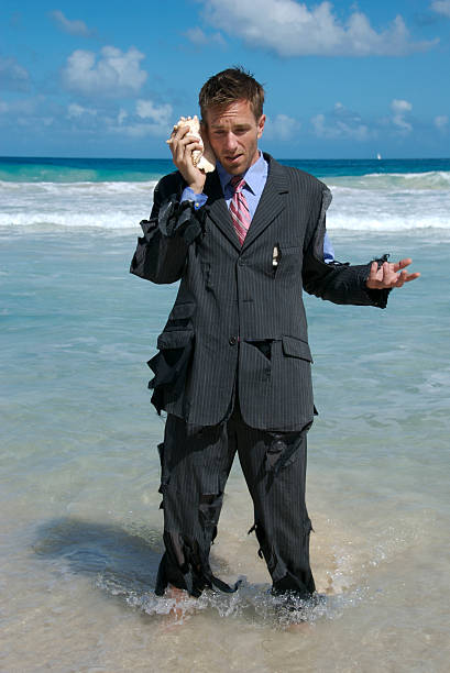 naufrago uomo d'affari sta tra le onde su cellulare - stranded beached beach businessman foto e immagini stock