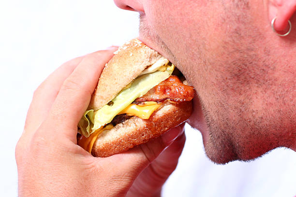 Young man eating a juicy burger stock photo