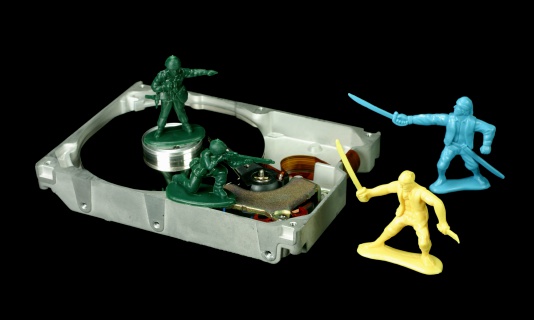 An open hard drive being guarded by little green army men and attcked by pirates.