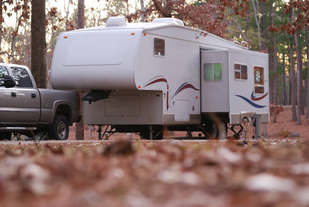 Fifth wheel at campsite Ground view of a fifth wheel camper trailer in a wooded campsite camper trailer photos stock pictures, royalty-free photos & images