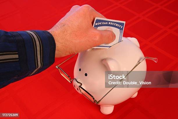 Hand Depositing Socialsecurity Card Into Piggy Bank With Glasses Stock Photo - Download Image Now