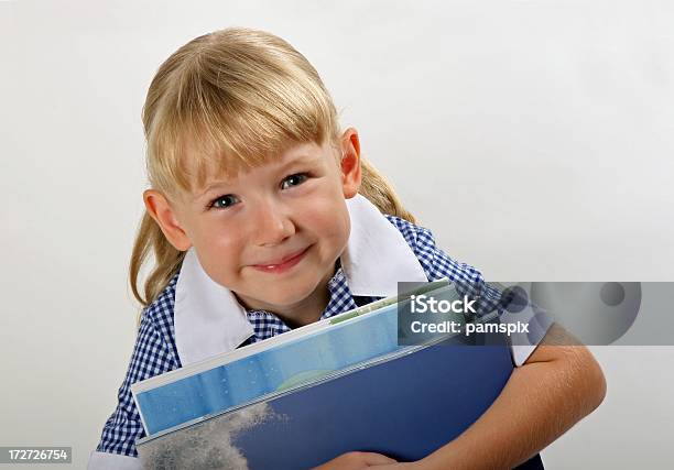 Photo libre de droit de Petite Écolière En Uniforme Scolaire Tenant Des Livres banque d'images et plus d'images libres de droit de 4-5 ans