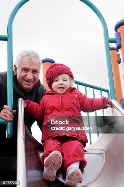 Abuelo Y Granduaghter En Diapositiva Foto de stock y más banco de imágenes de Tercera edad - Tercera edad, Tobogán, Deslizar