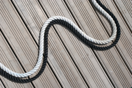 Black and white ropes snake together across a wooden dock