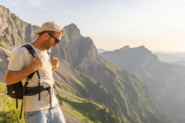 istock Man hikes along grassy mountain ridge at sunrise 1727277707