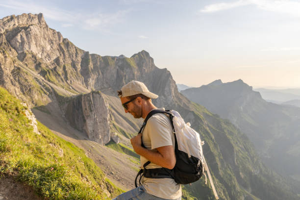 istock Man hikes along grassy mountain ridge at sunrise 1727277711