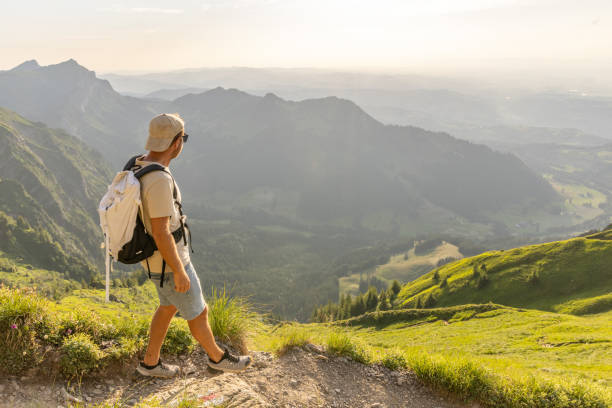 istock Man hikes along grassy mountain ridge at sunrise 1727278221