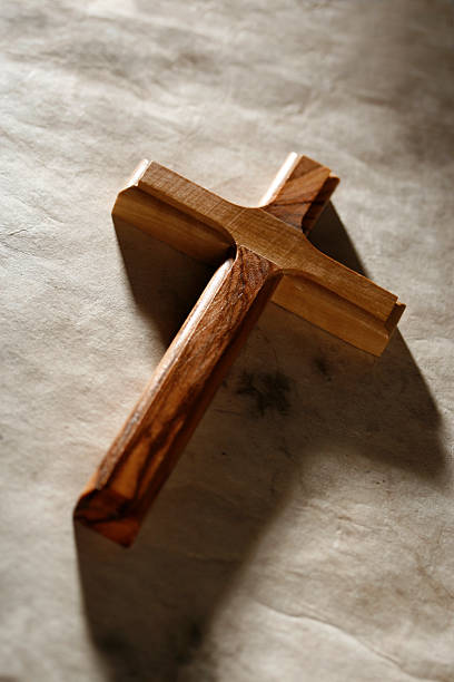 A crucifix, on a blue surface, with lighting from behind