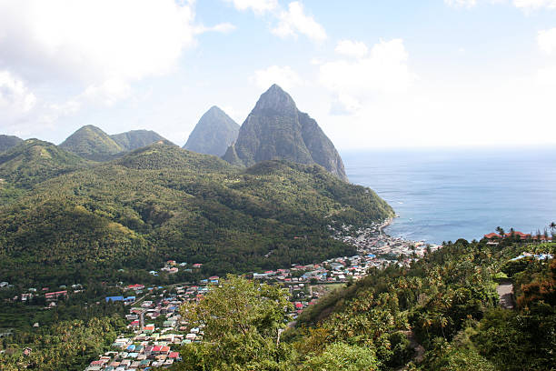 St Lucia Pitons Standing at 743 m (2,438 ft) and 798 m (2,618 ft) respectively, Petit Piton and Gros Piton are twin volcanic cones clothed in dense vegetation and are probably the best known landmark of the Caribbean. You can see also the soufriere bay.  St Lucia Voted World’s Best Honeymoon Spot.  extinct volcano stock pictures, royalty-free photos & images