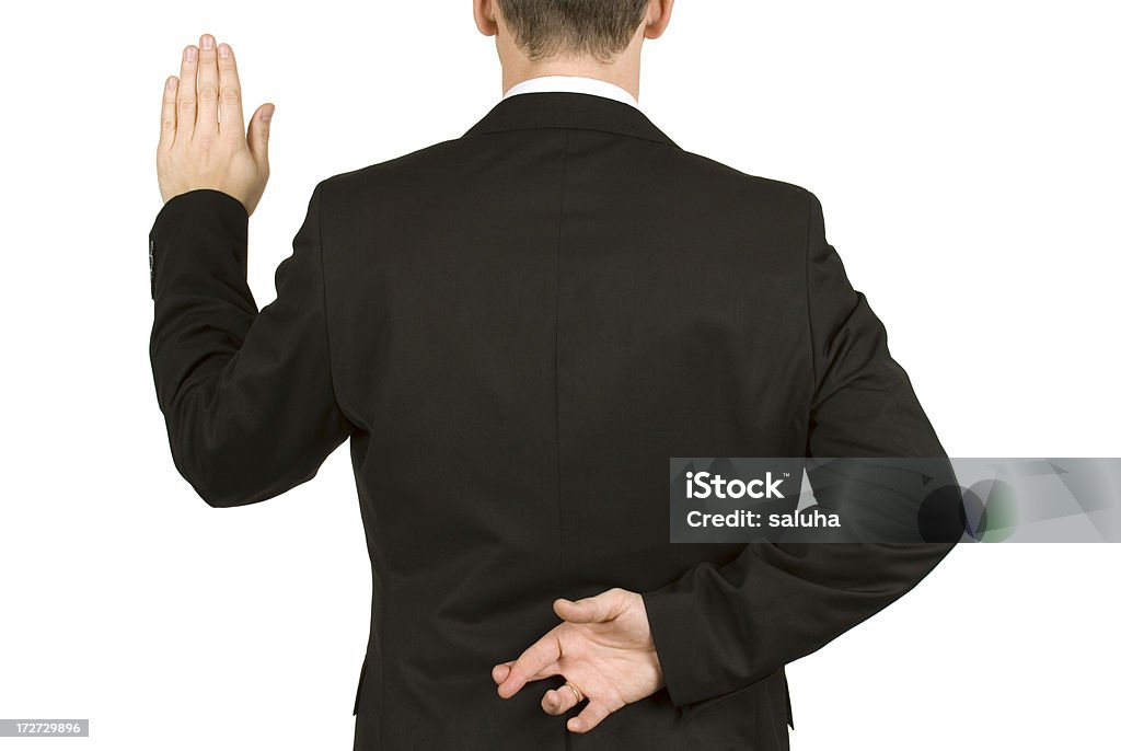 Man in suit taking oath while crossing fingers behind back Portrait of a junior businessman.  Morality Stock Photo