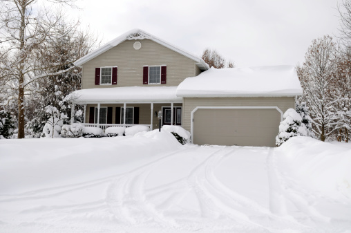 A snow covered middle class family home.
