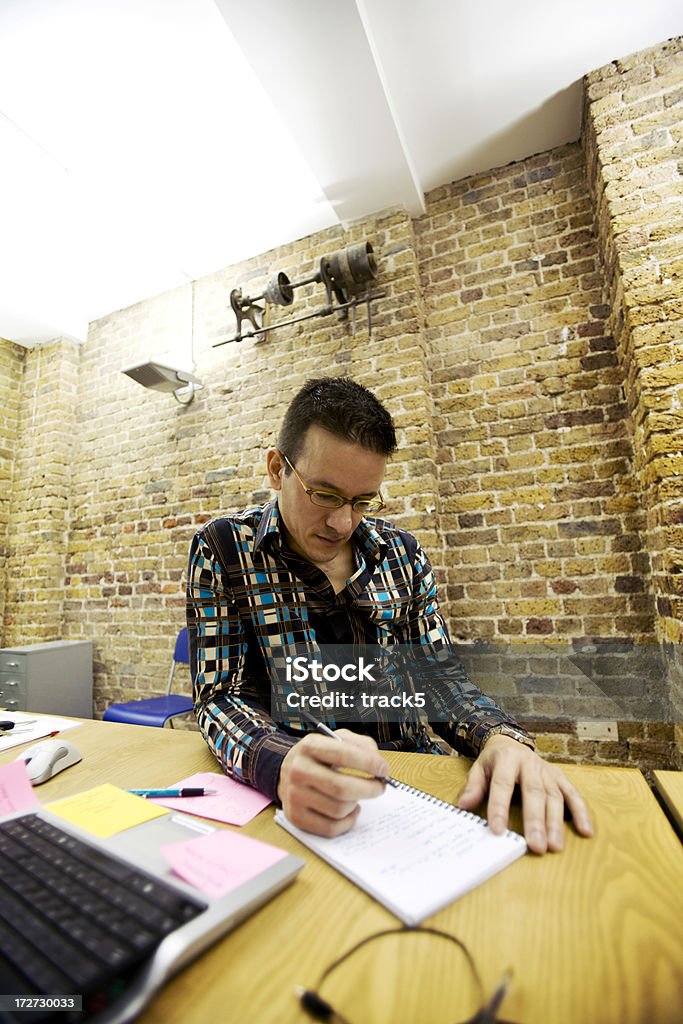 modern workplace: creative professional sketching ideas with pen and paper A worker check his list of tasks for the day. 30-39 Years Stock Photo