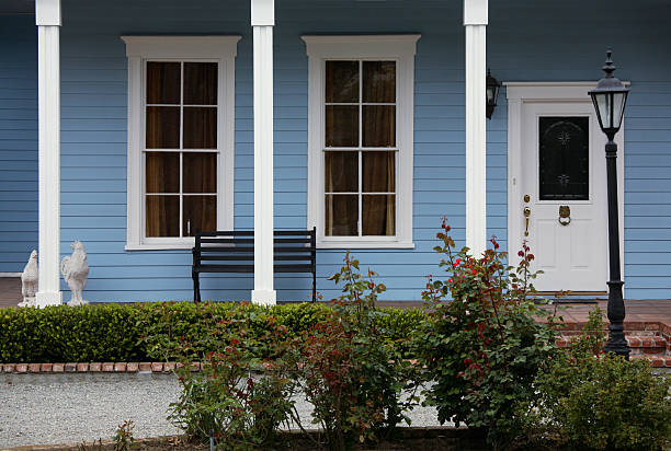 Yellow and red flowers growing along a white picket fence in traditional garden