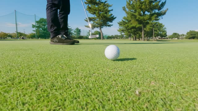 POV shot of a golf ball going in the hole