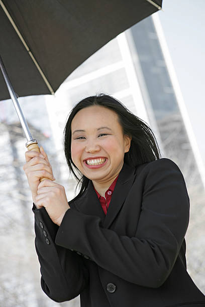 istock Smiling Businesswoman Under Umbrella Vertical 172732348