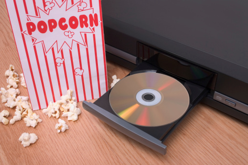 DVD movie and player alongside a bag of popcorn.