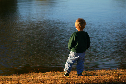 Small boy looking out over the lake.