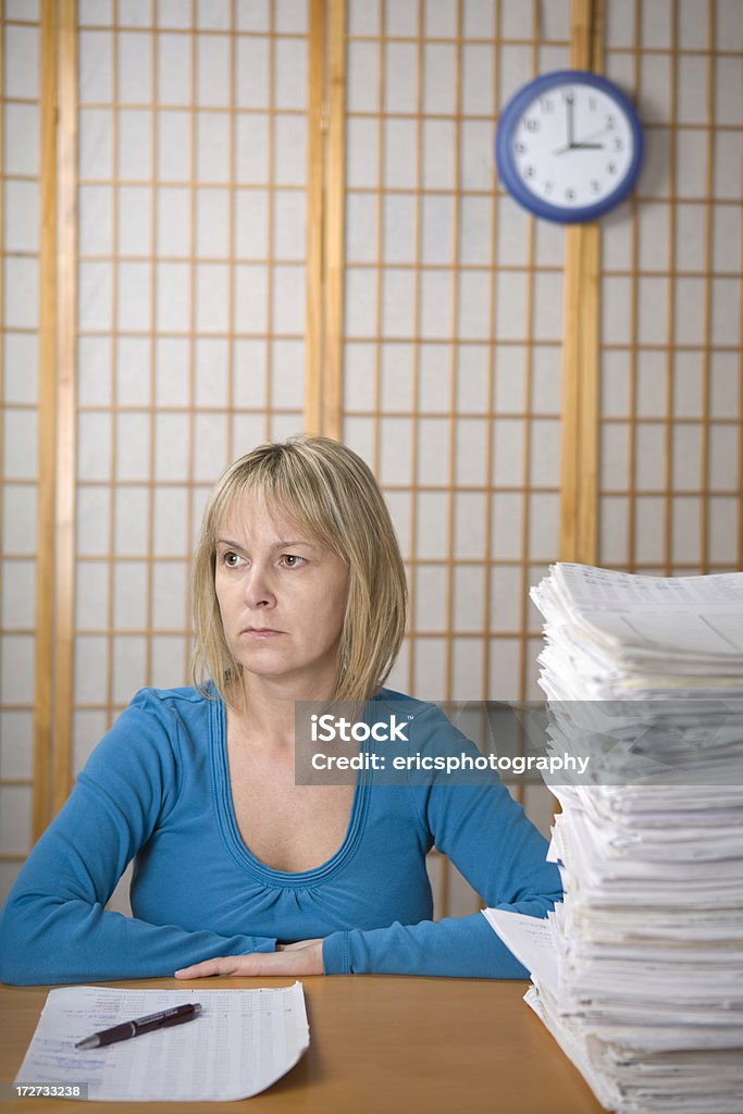 Not enough time Isolated on white. Female office worker behind a pile of papers. 35-39 Years Stock Photo