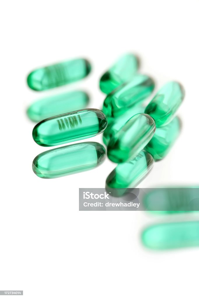 Prescription Drugs, close-up of Advil. Prescription pain killers spilt on reflective surface. Isolated on white background, selective focus. Pharmaceutical Industry. Beauty Stock Photo